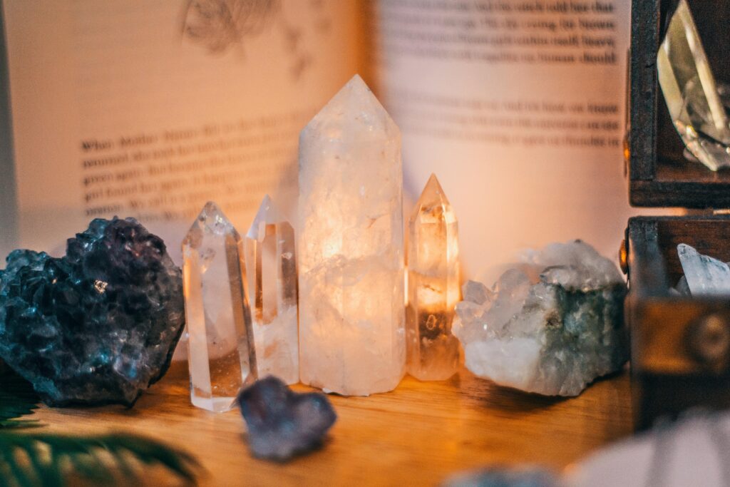 Close-up of various healing crystals on a wooden table with warm lighting